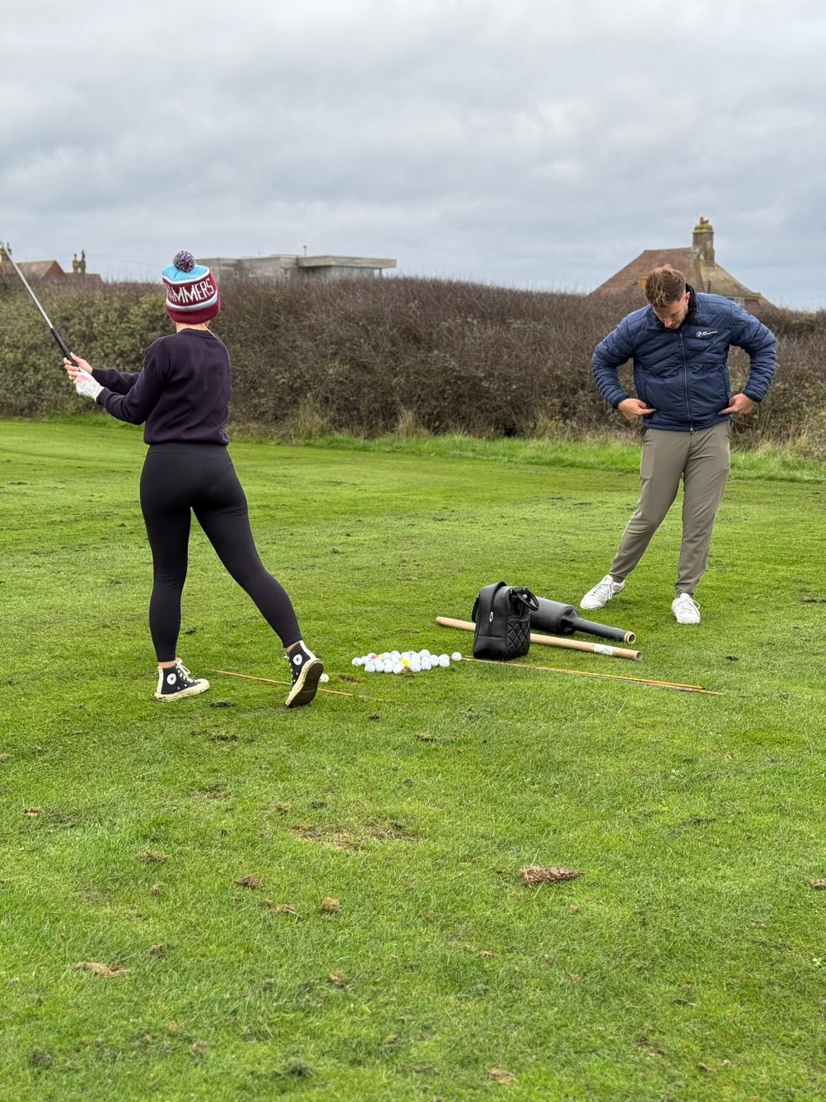 James providing professional golf coaching to a student on the course